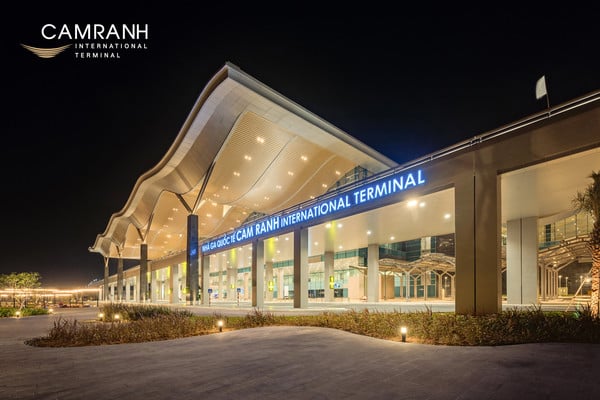Cam Ranh International Airport terminal exterior at night with modern wave-shaped roof illuminated by lights in Nha Trang, Vietnam.