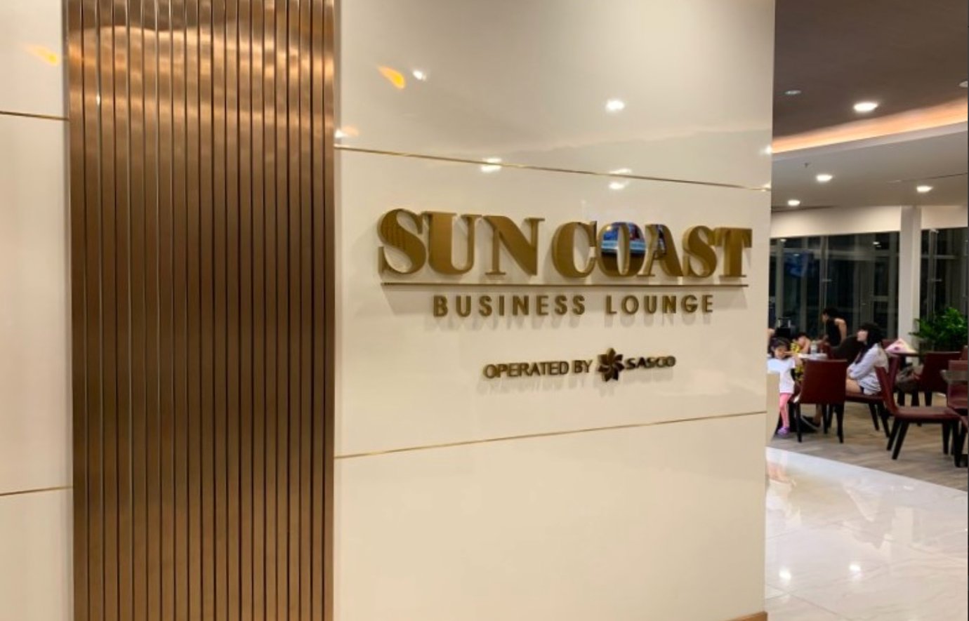 Entrance sign of Sun Coast Business Lounge at Cam Ranh International Airport Terminal 2, operated by SASCO, with seating area visible inside.