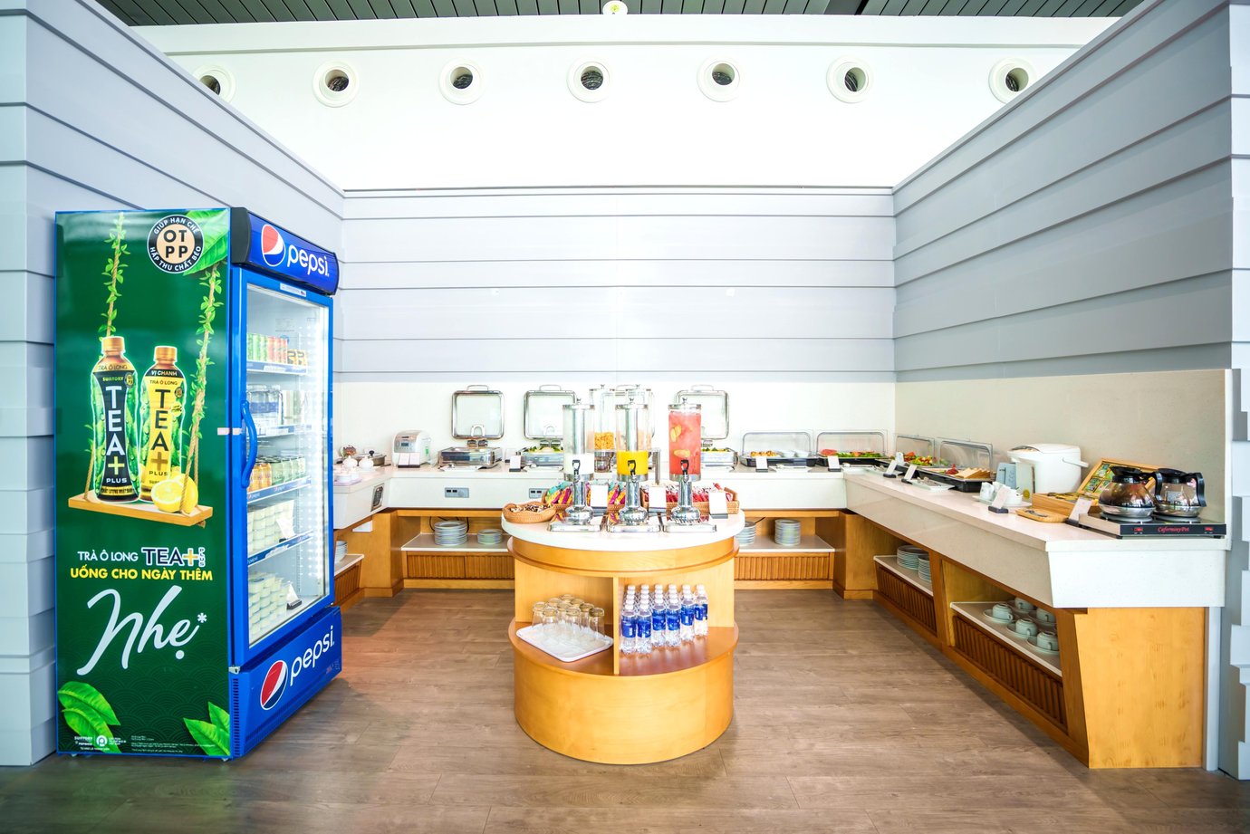 Self-service buffet area at SH Premium Lounge, Cat Bi International Airport (HPH), with hot food trays, salad selection, beverage dispensers, and a Pepsi-branded refrigerator along the wall.
