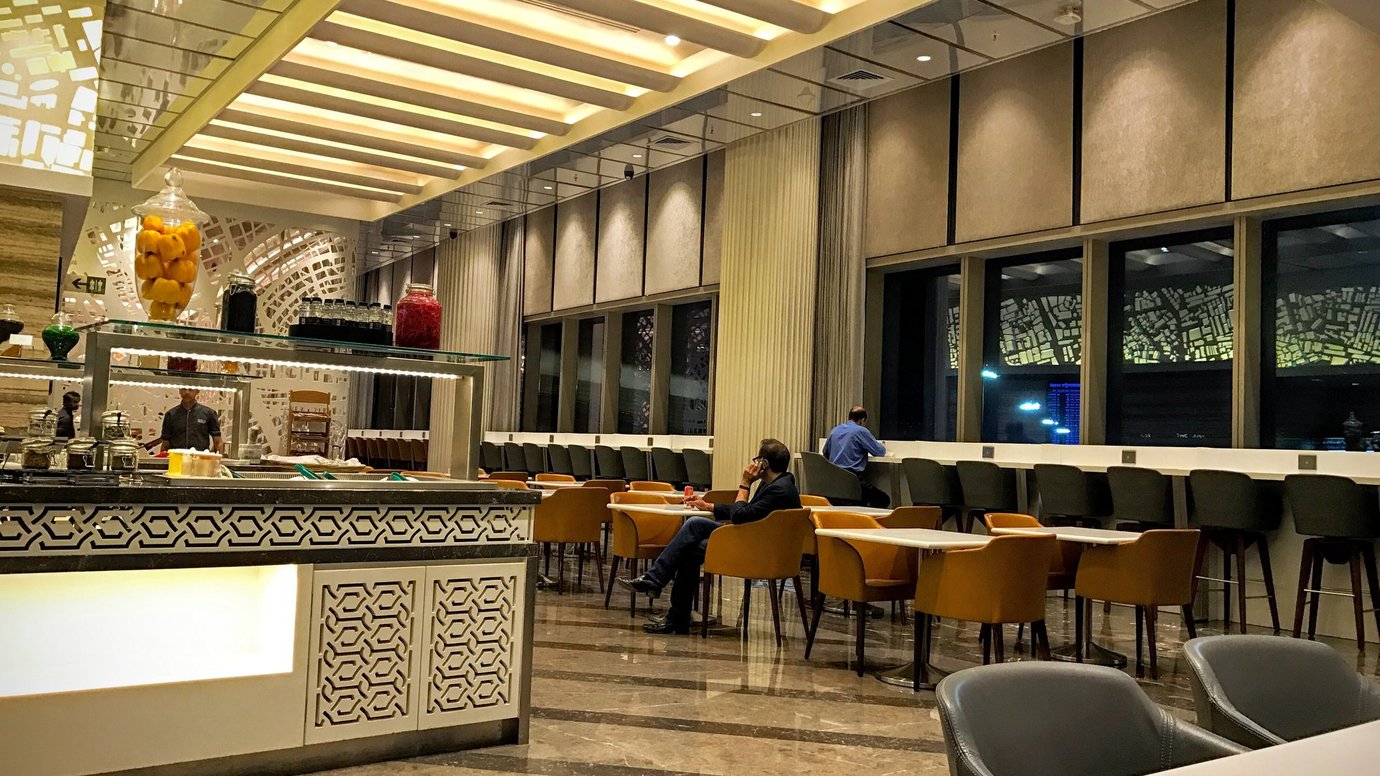 Adani East Lounge at Mumbai Airport Terminal 2 featuring modern seating, buffet counter and spacious dining area. Adani East Lounge at Mumbai Airport Terminal 2 featuring modern seating, buffet counter and spacious dining area.