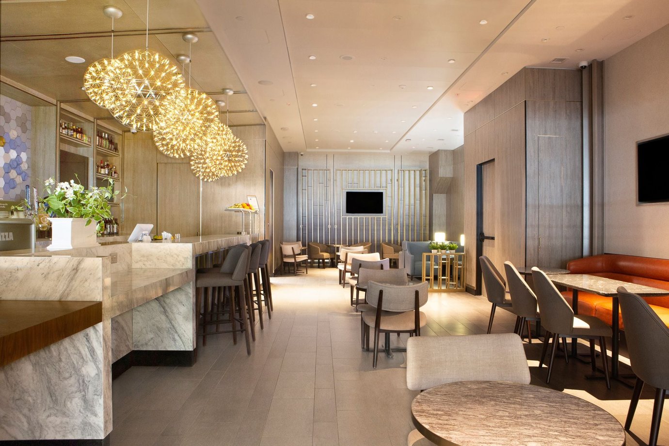 Main seating and social area inside the Plaza Premium Lounge at DFW Airport Terminal E. The space featuring marble surfaces, soft neutral tones, contemporary dining tables, lounge chairs, and a sleek bar counter. Main seating and social area inside the Plaza Premium Lounge at DFW Airport Terminal E. The space featuring marble surfaces, soft neutral tones, contemporary dining tables, lounge chairs, and a sleek bar counter.