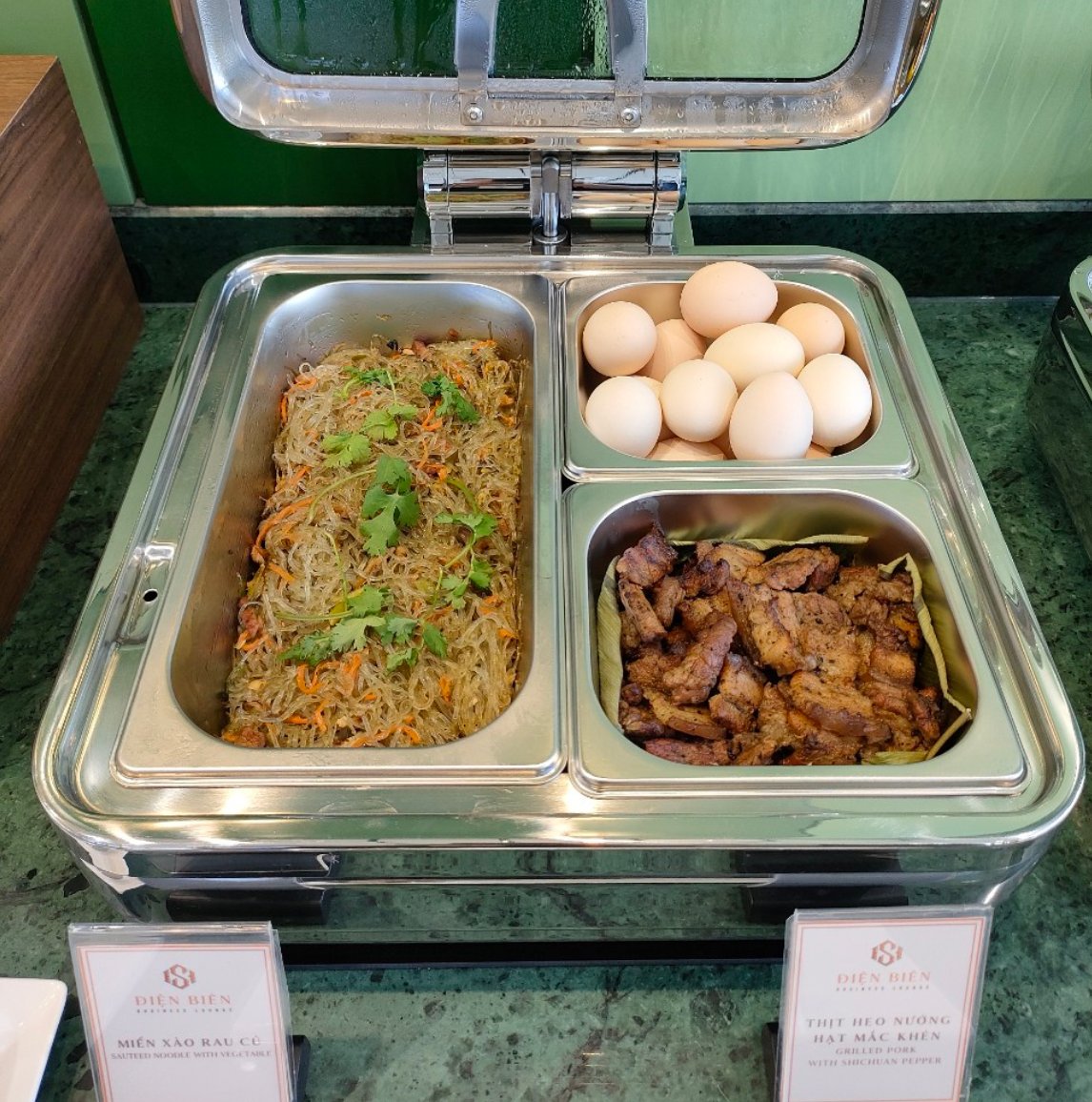 Hot food selection at Điện Biên SH Business Lounge, Điện Biên Phủ Airport (DIN), featuring sautéed glass noodles, boiled eggs, and grilled pork at the airport lounge buffet.