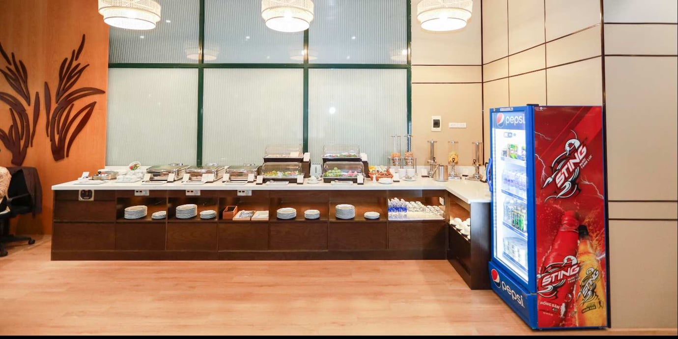 Buffet food and beverage station at SH Premium Lounge, Dong Hoi Airport (VDH), offering hot dishes, snacks, soft drinks, and self-service refreshments for departing passengers. Buffet food and beverage station at SH Premium Lounge, Dong Hoi Airport (VDH), offering hot dishes, snacks, soft drinks, and self-service refreshments for departing passengers.