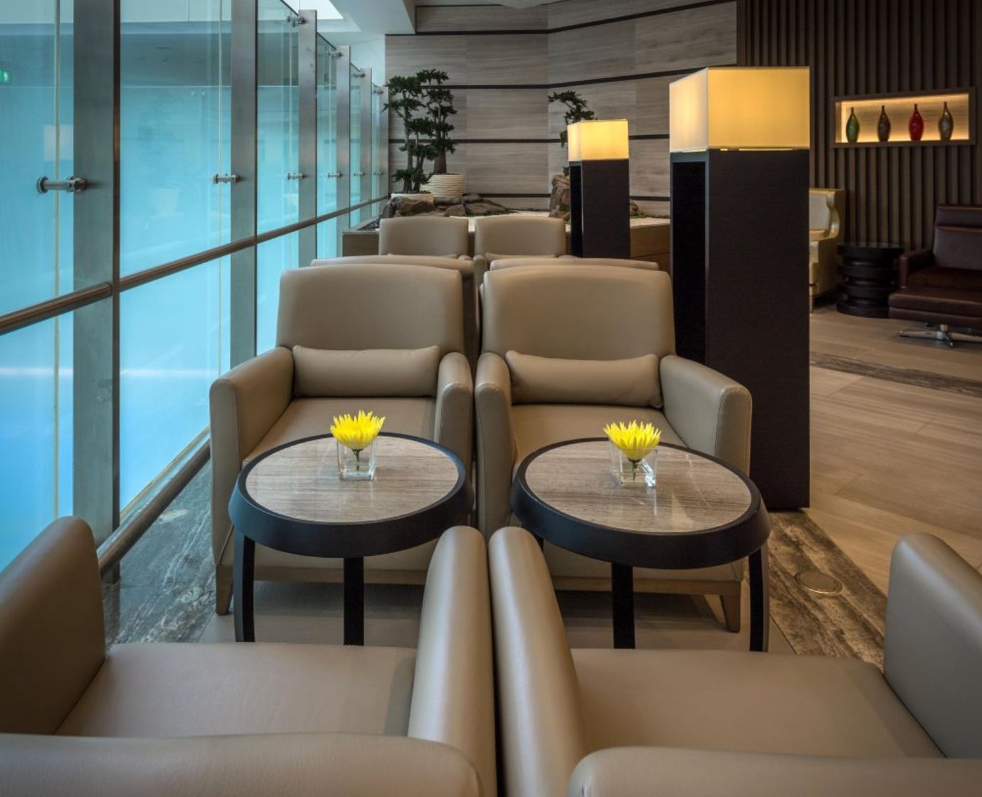 Comfortable seating area inside the Ahlan First Class Lounge at Dubai International Airport Terminal 1, featuring plush leather armchairs, soft lighting, and elegant décor overlooking the concourse. Comfortable seating area inside the Ahlan First Class Lounge at Dubai International Airport Terminal 1, featuring plush leather armchairs, soft lighting, and elegant décor overlooking the concourse.