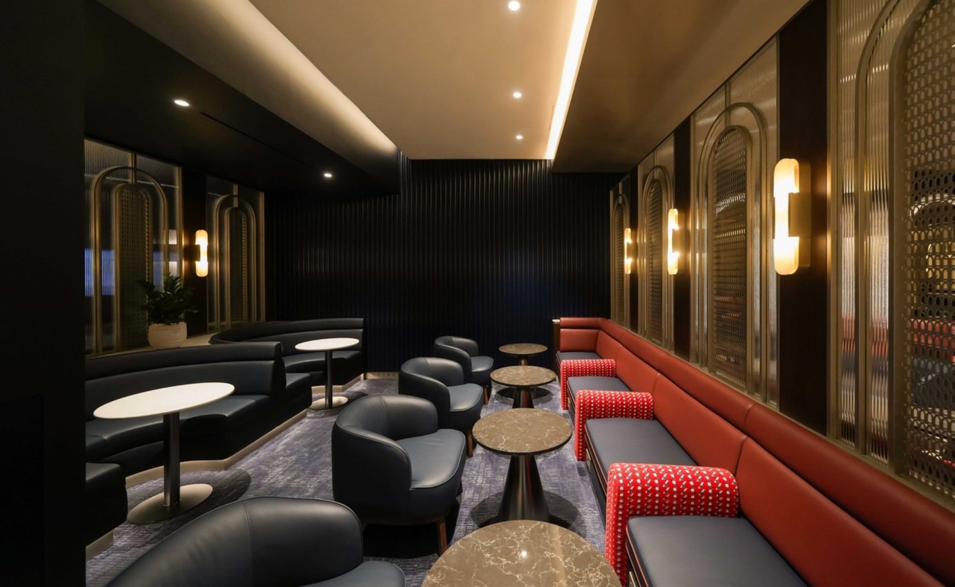 Contemporary seating area inside the British Airways Lounge at Dubai International Airport Terminal 1, featuring deep blue armchairs, red leather benches, marble tables, and soft ambient lighting in an elegant Art Deco-inspired setting. Contemporary seating area inside the British Airways Lounge at Dubai International Airport Terminal 1, featuring deep blue armchairs, red leather benches, marble tables, and soft ambient lighting in an elegant Art Deco-inspired setting.