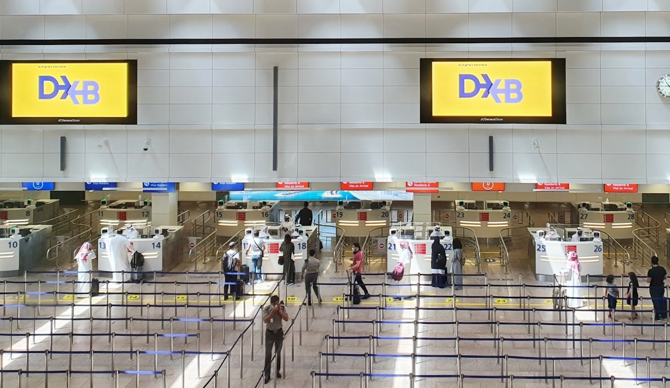 Passport control and immigration counters at Dubai International Airport (DXB) with travelers queuing under bright lighting and digital DXB signs. The organized check-in area highlights efficiency, modern design, and world-class airport service. Passport control and immigration counters at Dubai International Airport (DXB) with travelers queuing under bright lighting and digital DXB signs. The organized check-in area highlights efficiency, modern design, and world-class airport service.