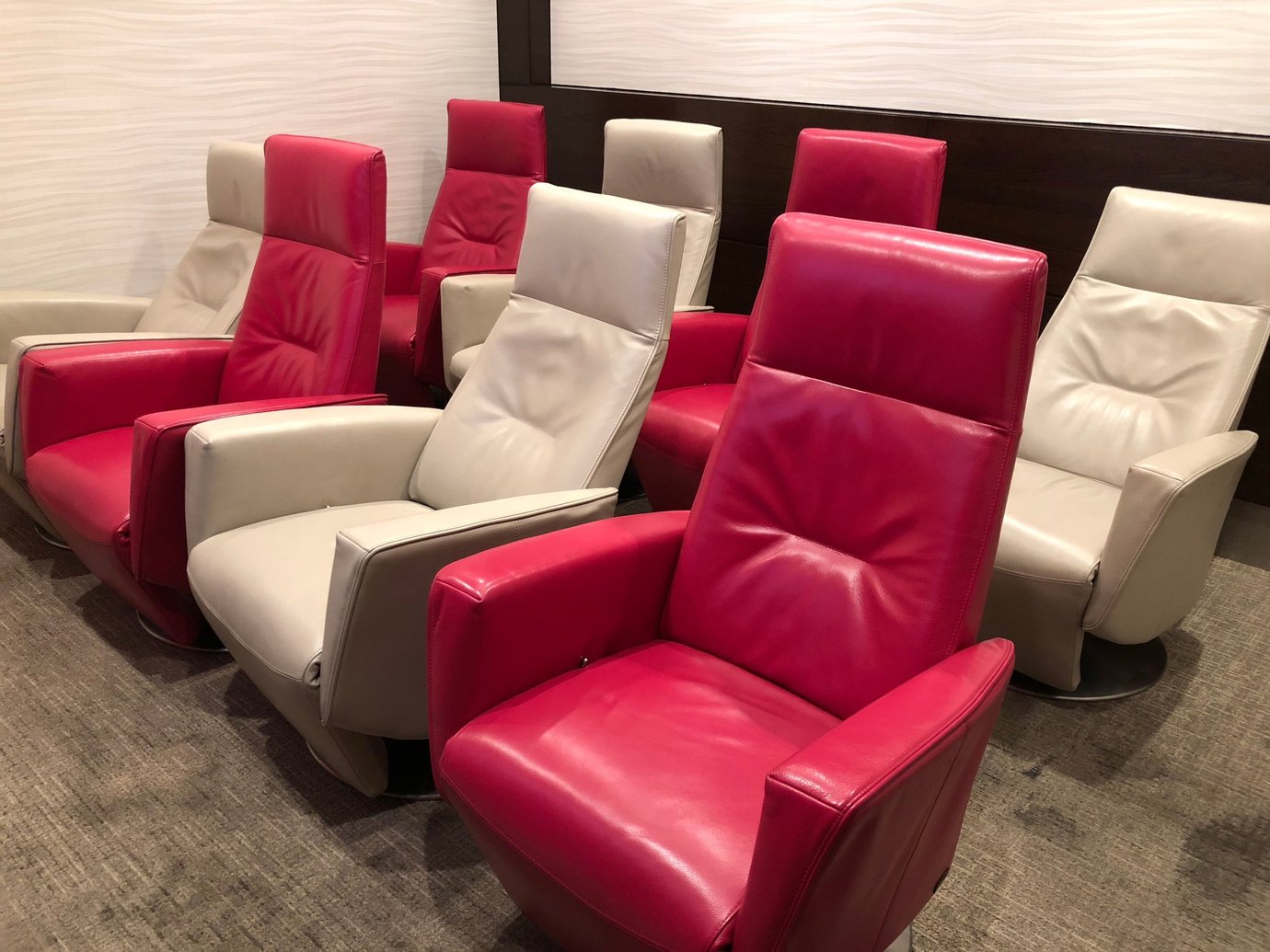Recliner seating area inside the Marhaba Lounge at Dubai International Airport Terminal 1, featuring comfortable red and beige leather chairs arranged for passenger relaxation before flights. Recliner seating area inside the Marhaba Lounge at Dubai International Airport Terminal 1, featuring comfortable red and beige leather chairs arranged for passenger relaxation before flights.