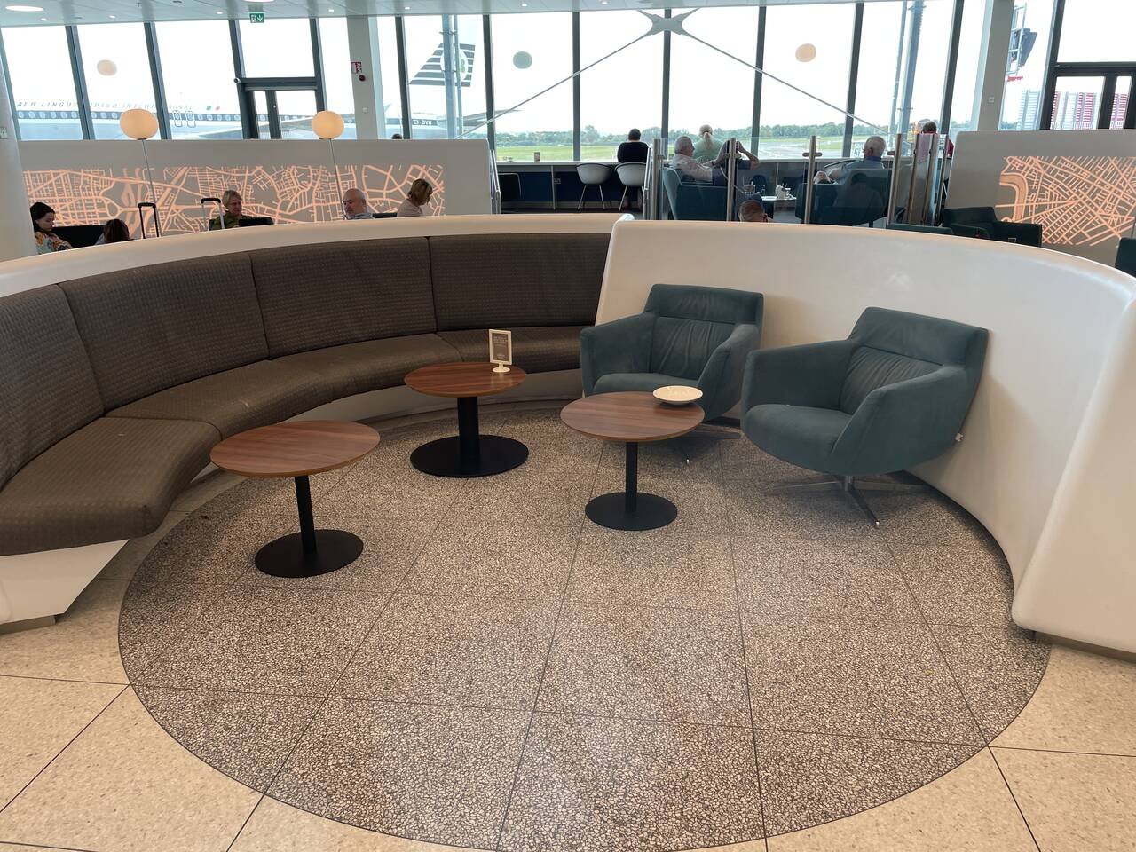 Luxurious 51st & Green Lounge at Dublin Airport with a curved sofa and chic coffee tables for travelers.