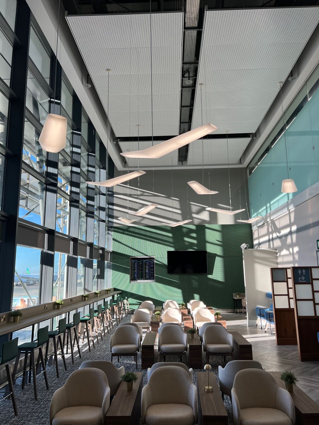 Layout of room with chairs and large windows within the Liffey Lounge at Dublin Airport