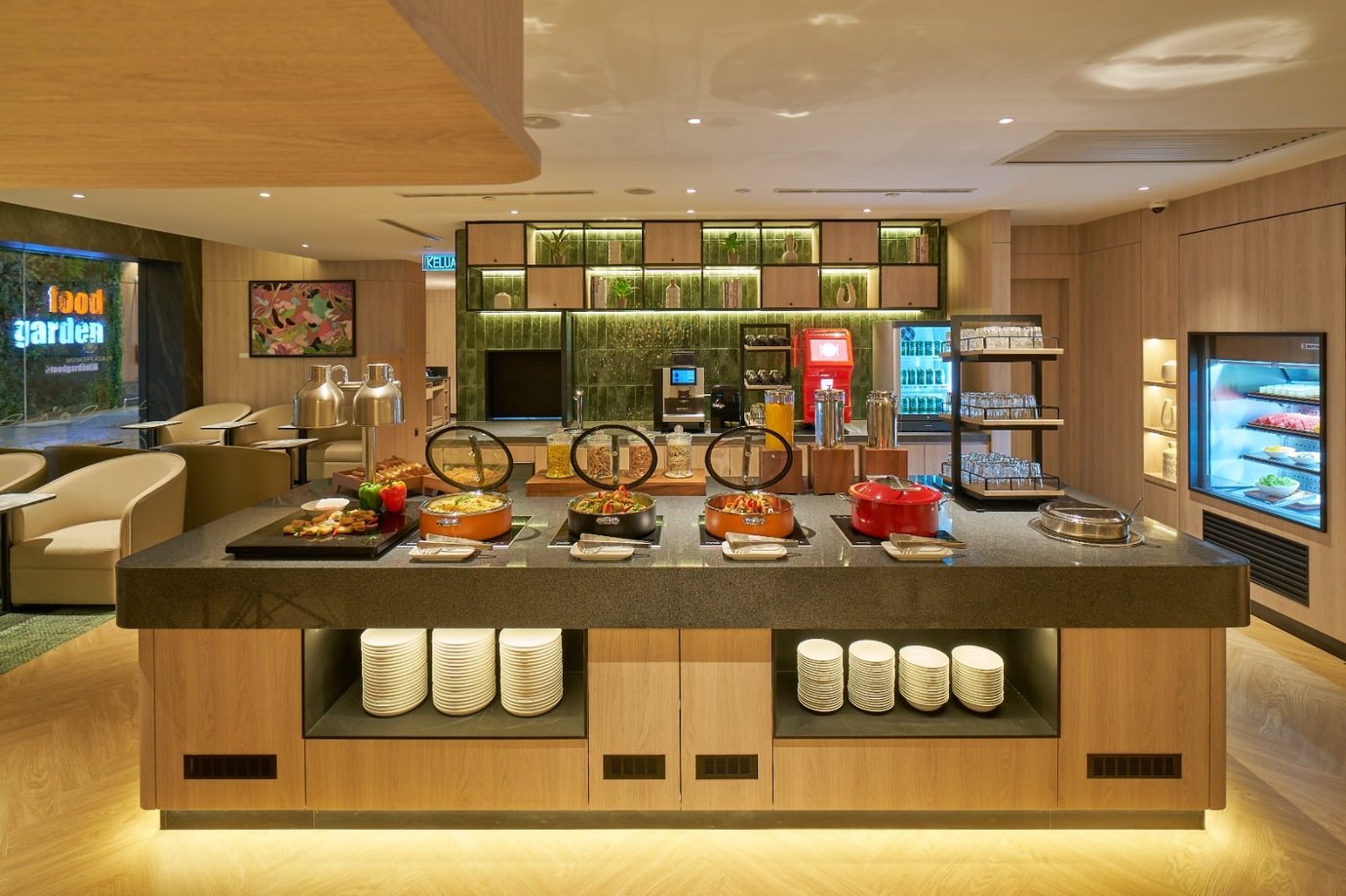 Food station at Plaza Premium Lounge, Langkawi Airport, with hot dishes, drinks, and buffet setup.