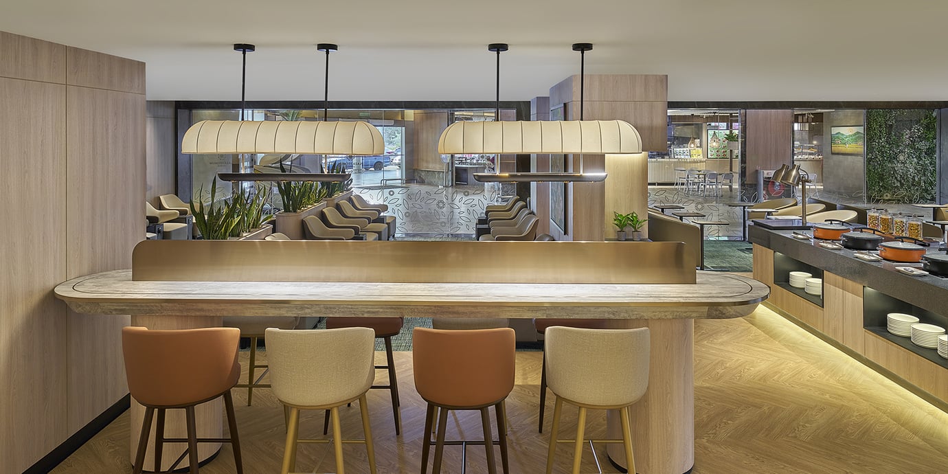 Plaza Premium Lounge at Langkawi Airport with bar seating, buffet counter, and modern interior.