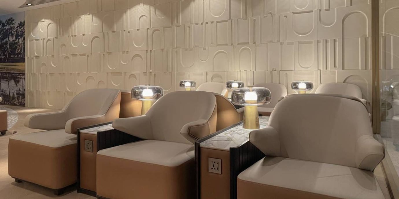 The seating area in Plaza Premium Lounge at Techo International Airport features comfortable chairs with individual lamps and power outlets.