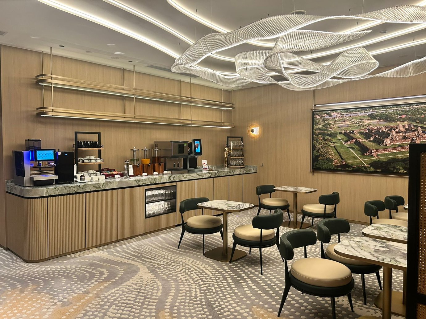 The Plaza Premium Lounge at Techo International Airport features a self-serve beverage station with seating for dining and relaxation.