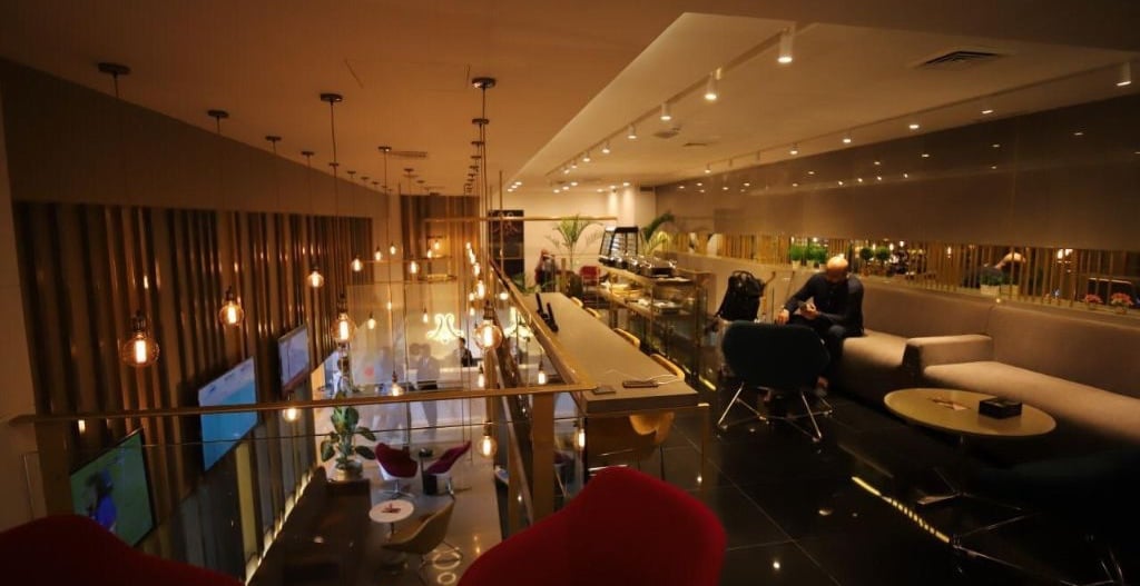 Upper-level seating area at Majestic Lounge, Jinnah International Airport (KHI), featuring contemporary sofas, pendant lighting, and elevated views of the lounge interior.