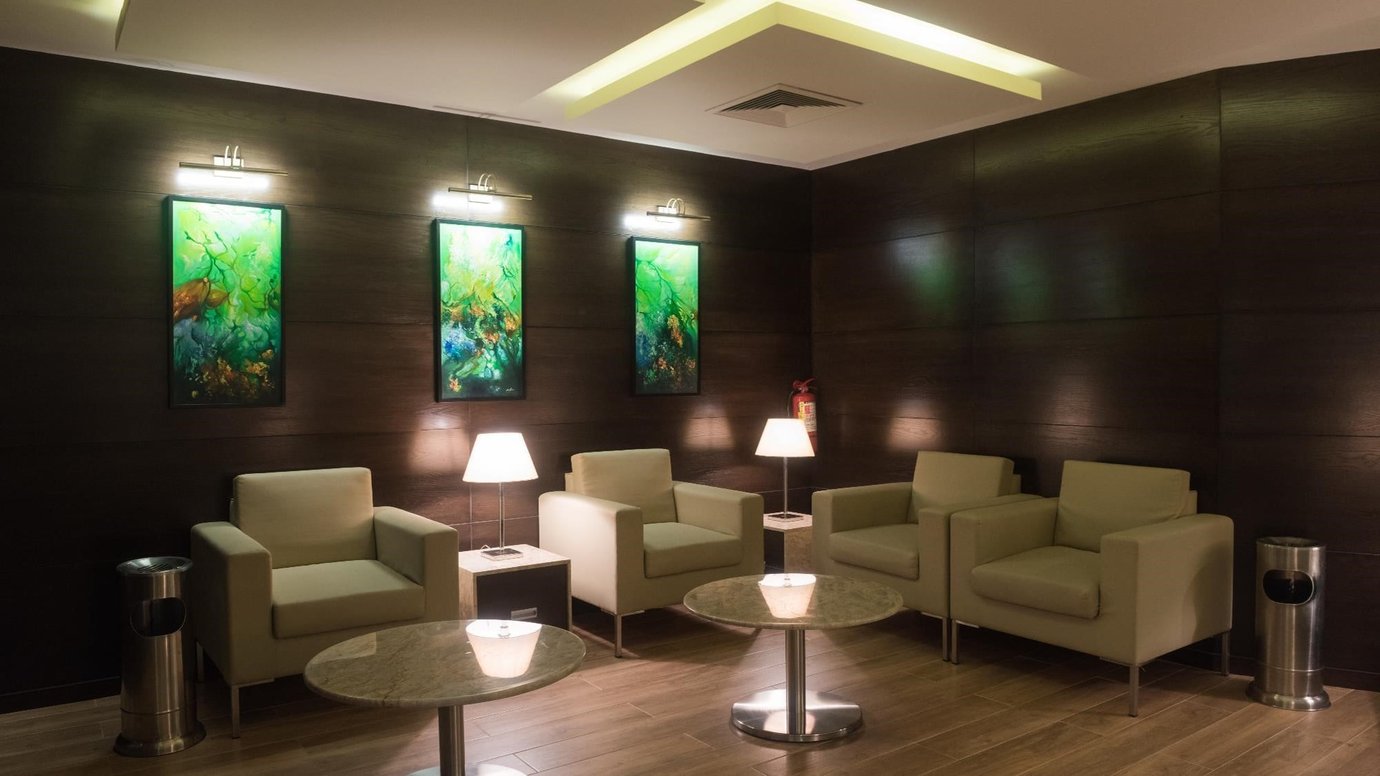 Quiet seating area inside Marhaba Premium Lounge at Jinnah International Airport (KHI), featuring comfortable armchairs, soft lighting, and contemporary artwork for a relaxed airport experience.