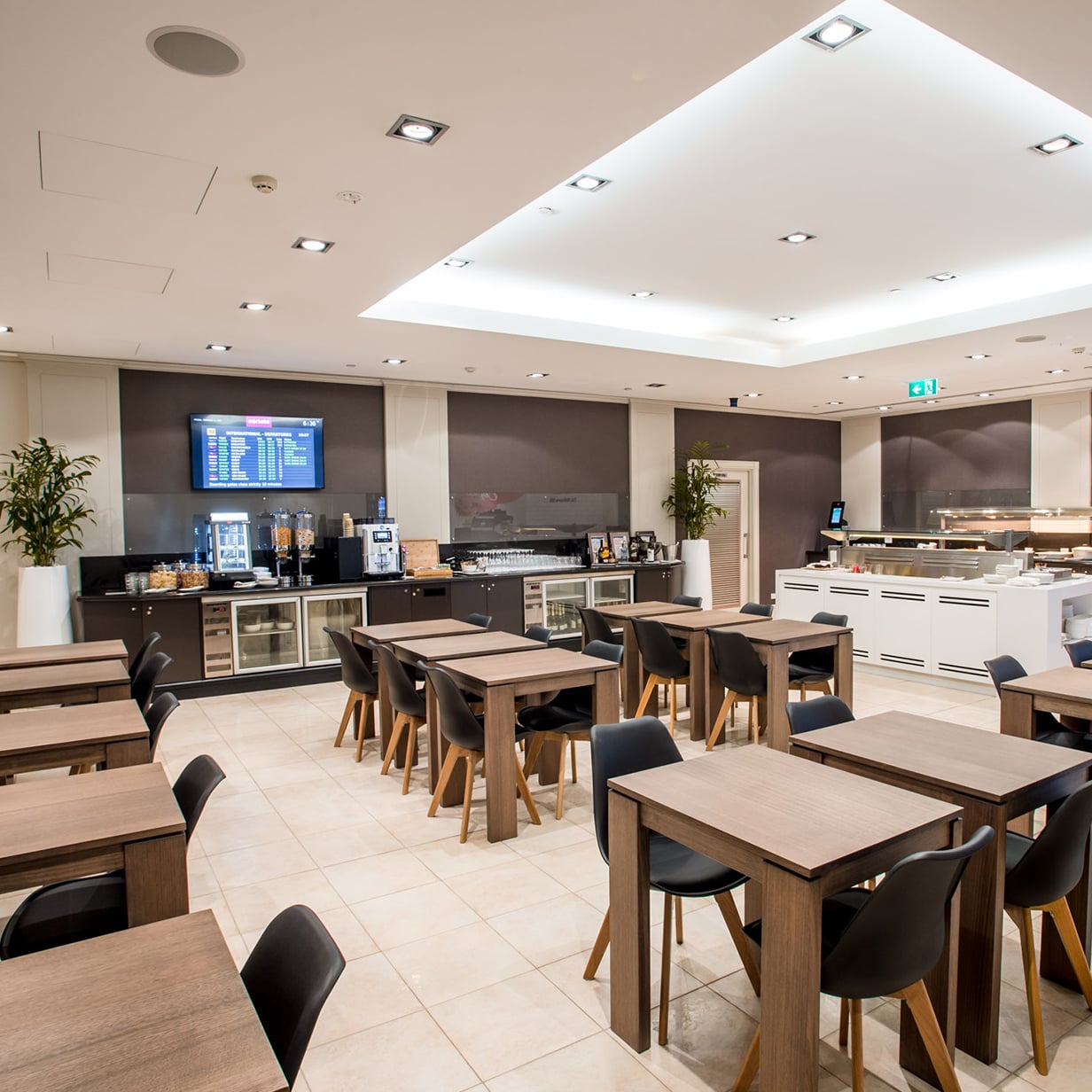 Marhaba lounge dining area at Melbourne Airport with tables, buffet counter, and self-service drinks station.
