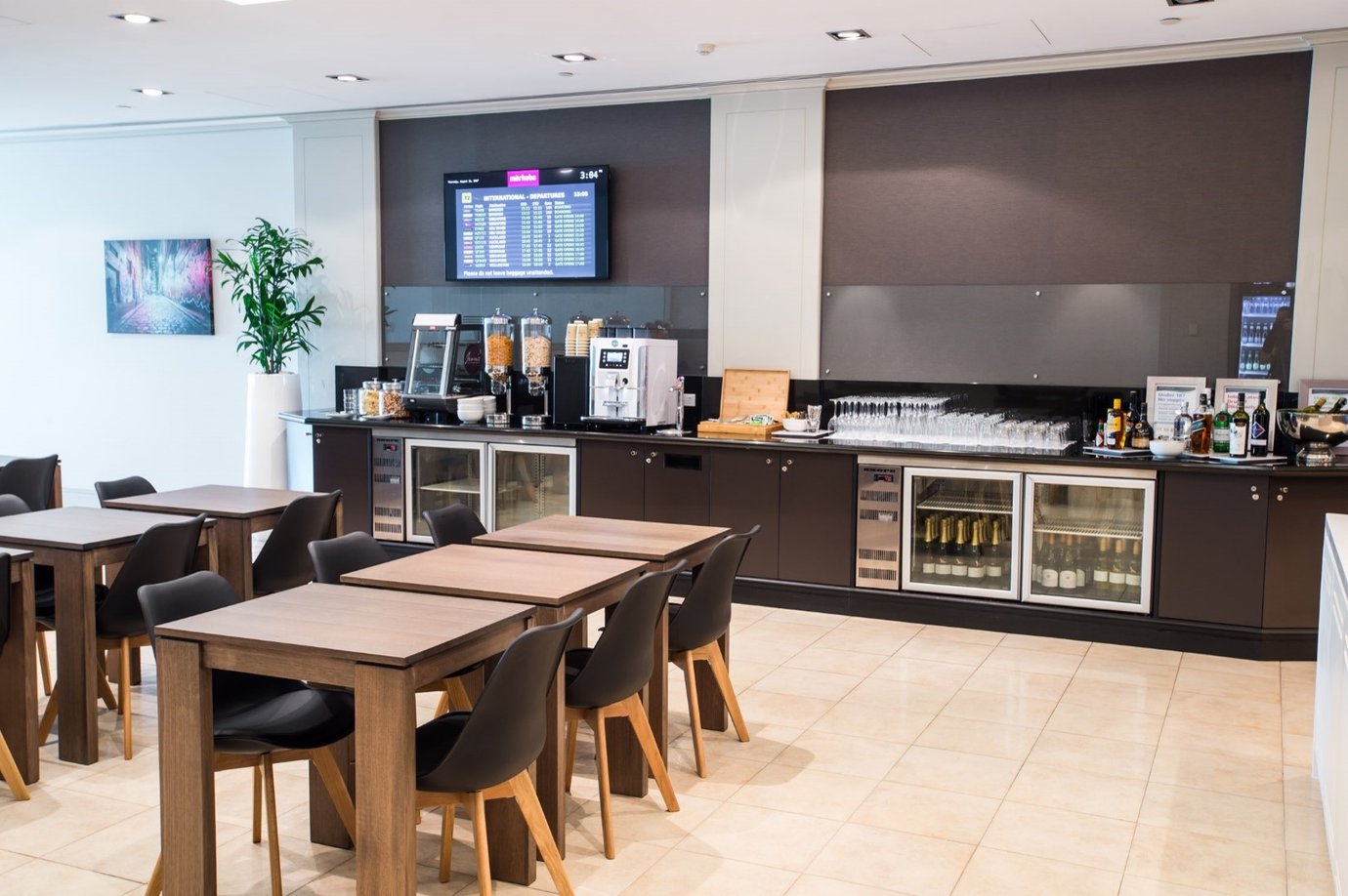 Marhaba Lounge at Melbourne Airport with dining tables, buffet counter, and self-service drinks area.