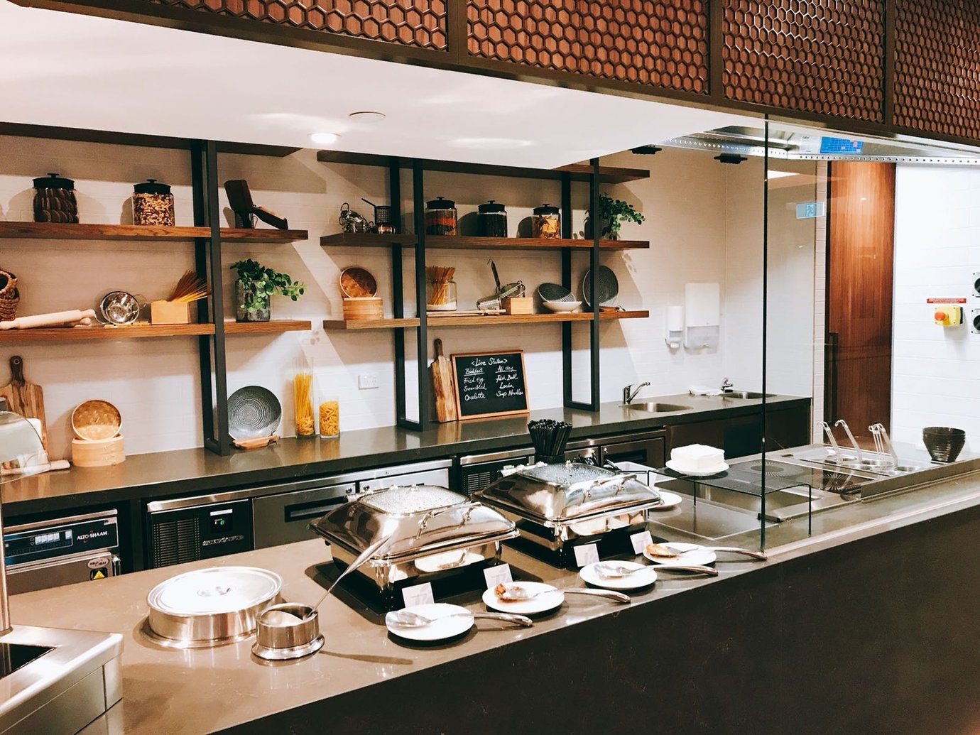Plaza Premium Lounge Melbourne Airport buffet with hot food station and modern open kitchen.