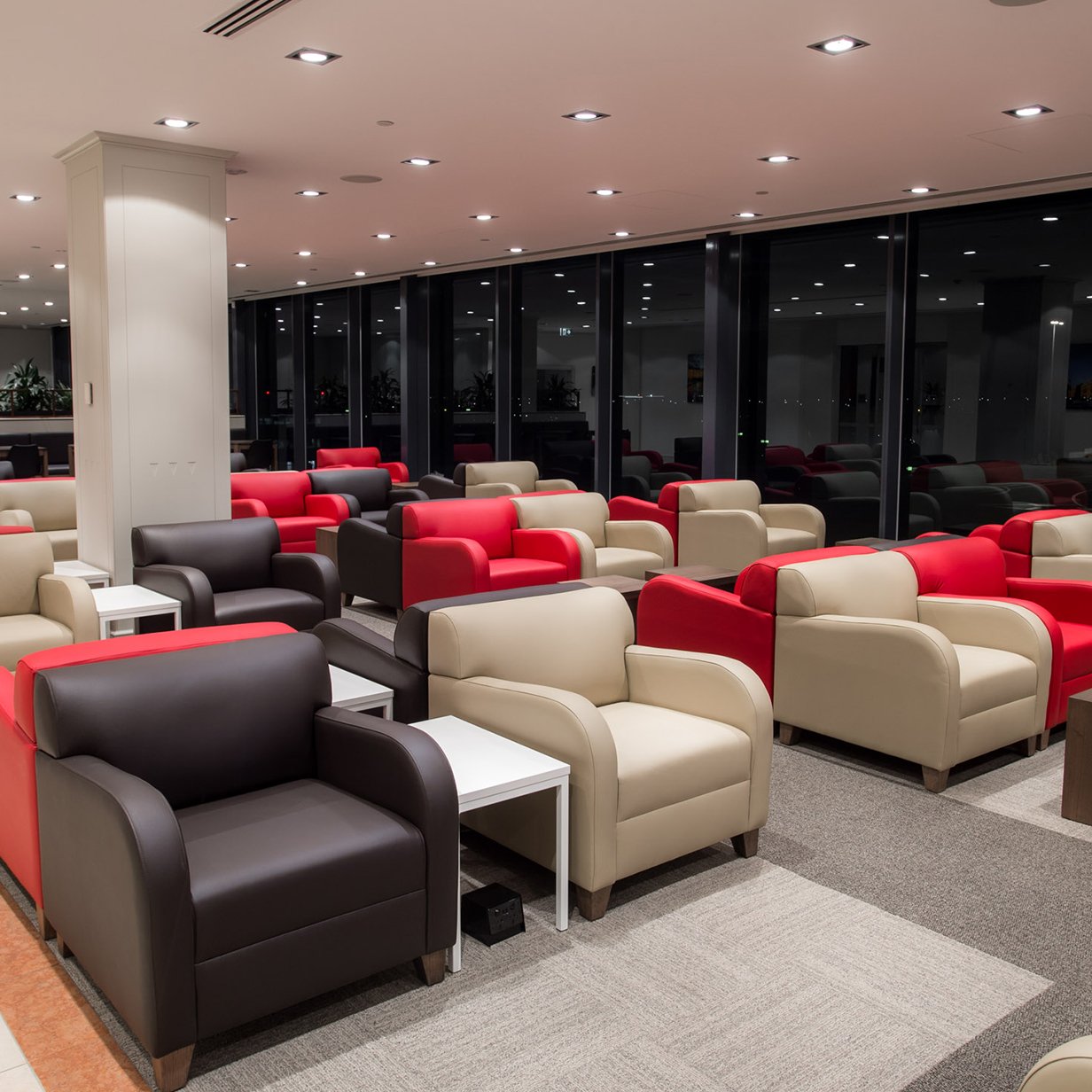 Marhaba Lounge Melbourne Airport seating area with leather armchairs and runway views at night.