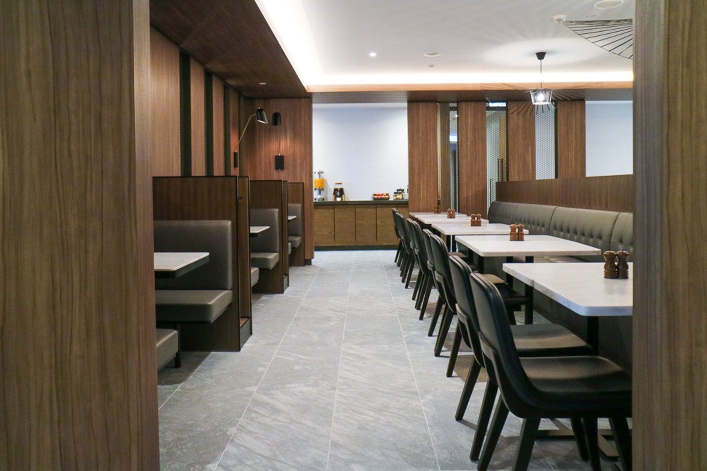 Plaza Premium Lounge Melbourne Airport dining walkway with booth seating and modern interior.