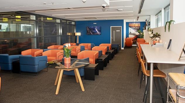 Rex Lounge at Melbourne Airport seating area with armchairs, communal high table seating, and a relaxed lounge space. Rex Lounge at Melbourne Airport seating area with armchairs, communal high table seating, and a relaxed lounge space.
