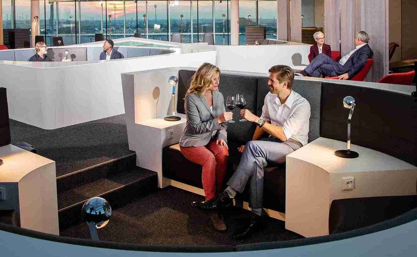 Zwei Personen teilen sich ein Glas Wein in der Airport Lounge World am Flughafen München