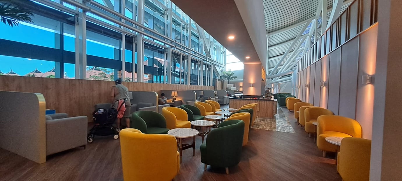 Concordia Lounge seating area at Ngurah Rai International Airport (DPS) Bali featuring floor-to-ceiling windows, modern armchairs, and premium departure lounge facilities.