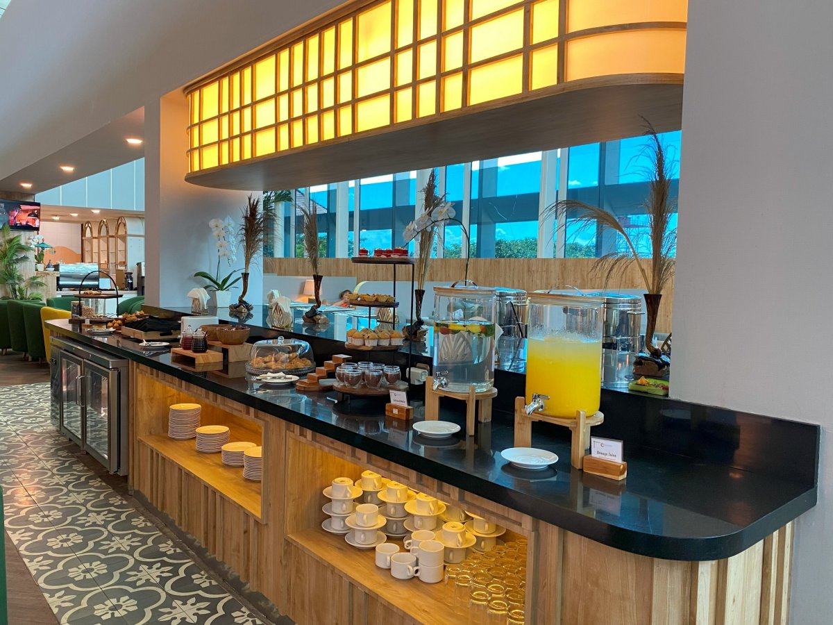 Concordia Lounge buffet at Ngurah Rai International Airport (DPS) Bali featuring self-serve drinks, pastries, hot dishes, and premium airport lounge dining facilities.