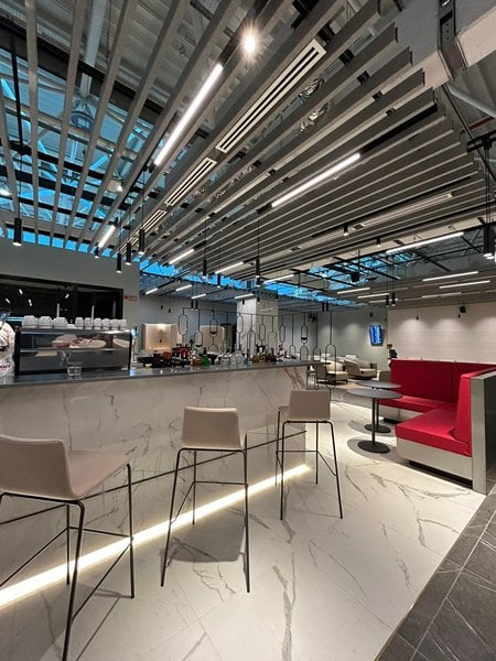 The Primeclass Lounge at Leonardo da Vinci-Fiumicino Airport features a bar with high stools and adjacent booth seating for travelers. The Primeclass Lounge at Leonardo da Vinci-Fiumicino Airport features a bar with high stools and adjacent booth seating for travelers.