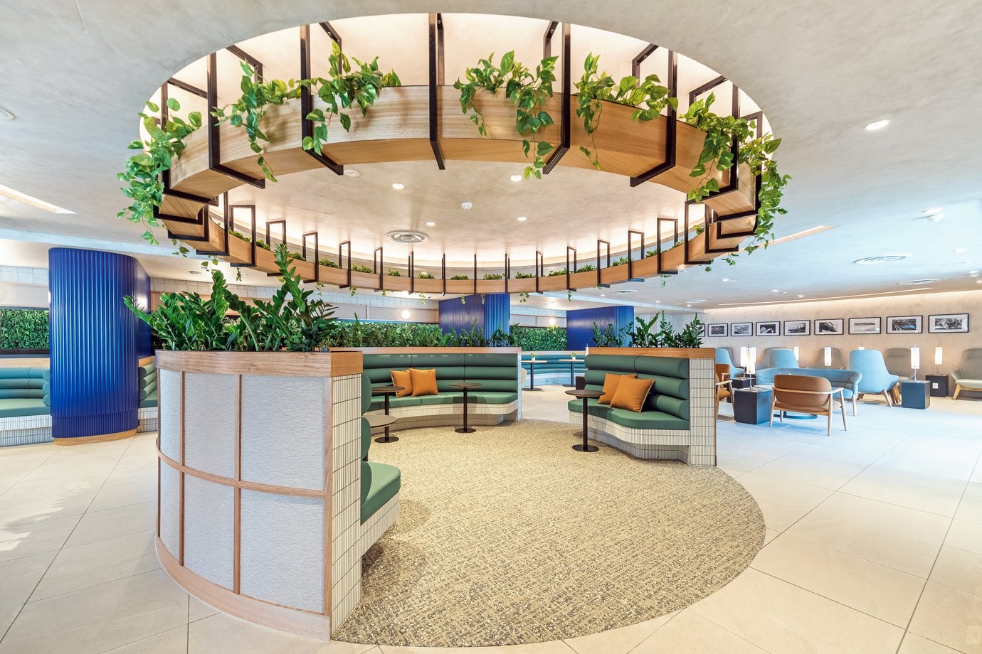 SkyTeam Lounge at Sydney Airport, circular booth seating beneath a timber feature with hanging greenery, alongside modern lounge chairs and tables.