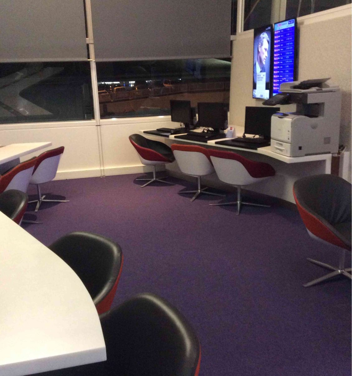 Virgin Australia Lounge at Sydney Airport workspace area with desktop computers, printer station, and seating overlooking the airfield.